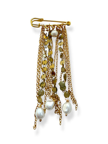 Tassel chains on safety pin with pearls white back background 