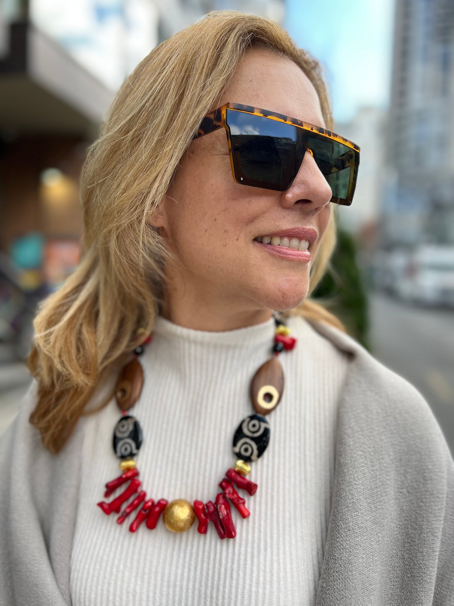 Statement necklace in coral wood and Tibetan agate on blond woman and white shirt inamullumani touch wood 