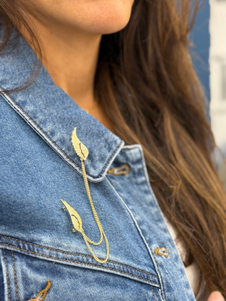 Gold wings brooch on a denim jacket