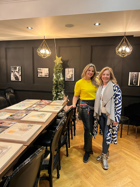 Two women standing in a room with vision board workshop wooden flooring and a decorative tree. Luma Qusus Awad Inamullumani 