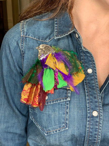 Silver bird brooch with upcycled material colorful fabrics on denim jacket