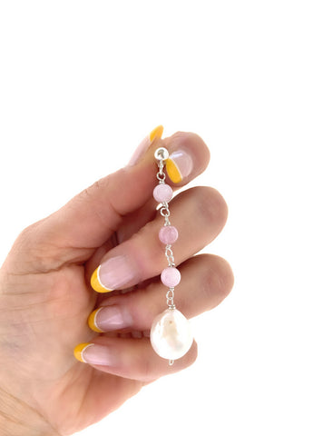 Hand holding an earring yellow nails kunzite stones baroque pearl handmade inamullumani luma Qusus awad